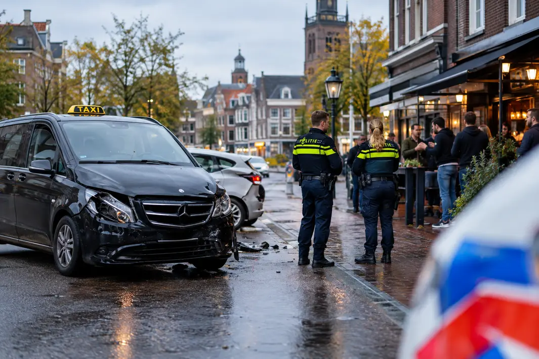 Taxibusje betrokken bij botsing in stad; politie reageert op kroegruzie